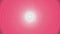 Smooth pink color soft spiral backdrop with a spinning spiraling rotation and light white center circle in a seamless loop