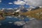 A smooth Riffelsee lake surface and mountains and clouds reflected in it, on a mountain Gornergrat, Switzerland