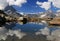 A smooth Riffelsee lake surface and mountains and clouds reflected in it, on a mountain Gornergrat, Switzerland