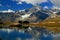 A smooth Riffelsee lake surface and mountains and clouds reflected in it, on a mountain Gornergrat, Switzerland