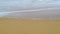 The smooth silky waves and seafoam on the sandy beach, long exposure photograph