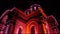 Smooth sliding shot of St. Michael the Archangel Church Soboras illuminated by various colors at night in Kaunas, Liberty Boulev