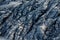 Smooth, undulating surface of frozen pahoehoe lava. Frozen lava wrinkled in tapestry-like folds and rolls resembling twisted rope