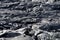 Smooth, undulating surface of frozen pahoehoe lava. Frozen lava wrinkled in tapestry-like folds and rolls resembling twisted rope