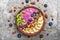 Smoothie bowl with fresh berries, fruits, nuts, seeds and homemade granola for healthy vegan diet breakfast