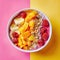 Smoothie bowl with fruits and granola on yellow and pink background