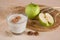 Smoothie juice on wooden table with walnut, cereals and apples