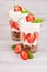 Smoothies with chocolate balls corn flakes decorated mint and slice strawberry on white wood board.