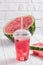 Smoothies Of Watermelon Juice In A Plastic Cup With A Straw. Fresh Red Drink With Ice On The White Background Of Wooden Planks. C