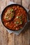 Smothered food Swiss steak in a spicy tomato sauce with vegetables close-up. Vertical top view