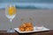 Snack called Dadinho de tapioca made with rennet cheese and tapioca flour, served with pepper jelly. tropical drink and beach in