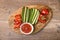 Snack for lunch: caviar and sliced pepper, cucumber and tomato on a wooden board