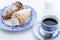 snack with puff pastry cannoli filled with whipped cream and a cup of coffee, still life on white background , close-up