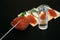 Snack with red caviar and glass of cold vodka on black wooden background. Spirits and traditional starter