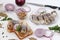 Snack from salted herring on bread with red onion and mustard on white background