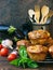 Snack savory muffins cakes with eggplant, tomatoes, basil and cheese on wooden background.