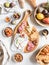 Snack set table. Variety of cheese, olives, sausage, baguette slices, figs on wooden board grey background, Flat lay. Top view