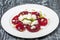 Snack of slices of boiled beetroot with goat cheese, lettuce and pine nuts in restaurant