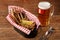 Snack to beer - fried small fish, lemon with a glass of light beer on a wooden table