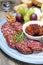 Snacks on a plate - sausage, sun-dried tomatoes, nuts, fruit