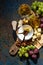 Snacks, wine and camembert on a dark background, vertical