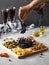 Snacks for wine in a wooden menagerie. Cheese, sausages, berries in a plate, festive serving of snacks.