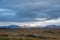 Snaefellsness national park in Iceland Snaefellsjoekull glacier in sunlight spot next to wave form clouds