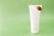 Snail cosmetic.Snails on a white tube on a green background.Organic natural cosmetics with snail slime.Cosmetic tube