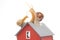 Snail on the roof of a house model on a white background. The concept of home comfort and life in the house