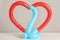 Snake and heart figures made of modelling balloons on table