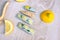 Snap hair clips with embroidered lemons on wooden background with slices of lemon around