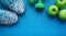 Sneakers, apples and dumbbells fitness on a blue background.