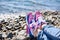 Sneakers girl on background of sea and rocky beach
