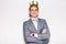 Sneering young handsome man wearing suit and crown keeping arms crossed