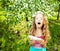 Sneezing girl near blowing trees