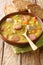 Snert Split Pea Soup with vegetables,  smoked sausages and pork closeup in the plate. vertical