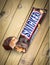 Snickers chocolate bar on wooden background