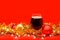 Snifter glass of dark beer with christmas lights baubles and tinsel on red background