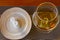 Snifter wine glass with cognac or brandy next to the plate with wet warm hand towels on a table. Top view