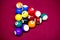 Snooker multicolored balls lay as a pyramid on the table. Closeup view. Billiard red table with cue and balls. Leisure, hobby,