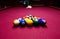 Snooker multicolored balls lay as a pyramid on the table. Closeup view. Billiard red table with cue and balls. Leisure, hobby,