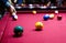 Snooker multicolored balls lay on the table. Closeup view. Billiard red table with cue and balls. Leisure, hobby,