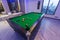 Snooker Pool Billiards green table with complete set of balls and two poo cues in a modern games room