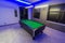 Snooker Pool Billiards room, green table with complete set of balls in a modern room with neon lights