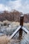 Snow accumulation on winter tree branches and fence posts in desert valley