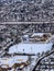 Snow art: Aerial view city blanketed with snow outlining two function buildings a recreational area covered with snow.