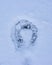 Snow background with a single horseshoe track.