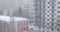 Snow blizzard blowing snowflakes sideways, with a modern, tall apartment building in the back, in Bucharest, Romania