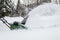 Snow blower in action clearing a residential driveway after snow storm