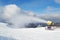 Snow cannon machine blowing artificial snow on Azuga ski domain, Prahova Valley region, Romania, during the Winter low season.